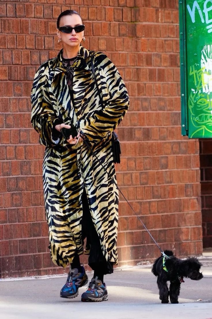 Street-style reference: an oversized zebra coat styled with trainers