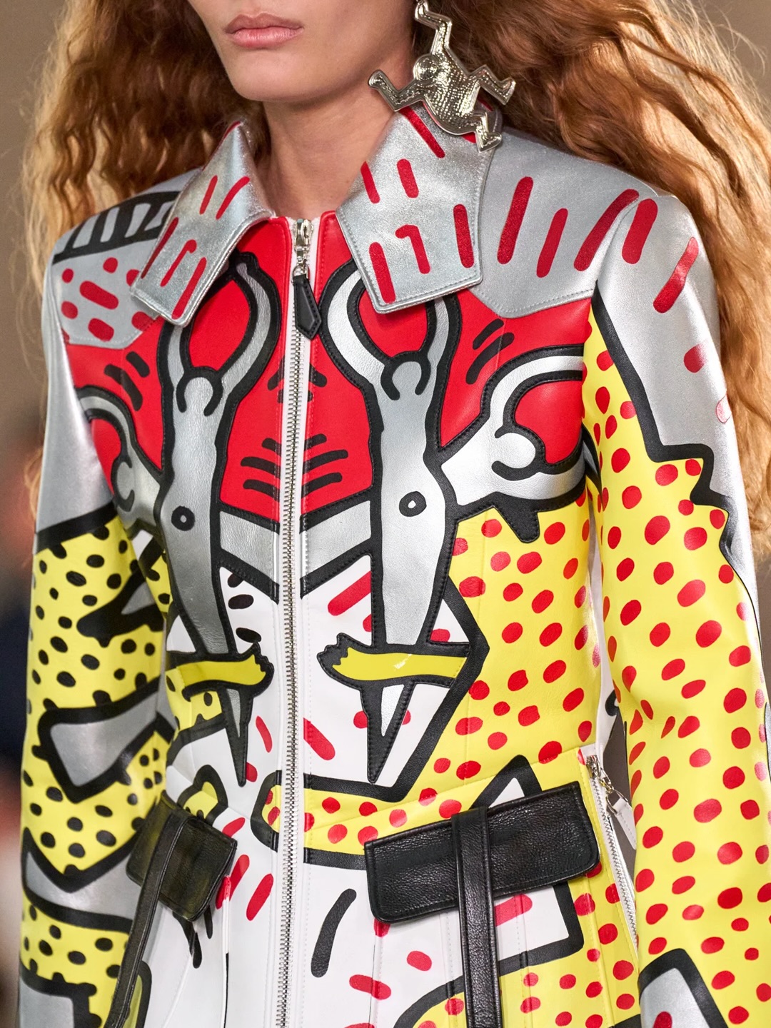 Close-up of a silver, red, yellow and black Louis Vuitton leather jacket covered in Keith Haring figures