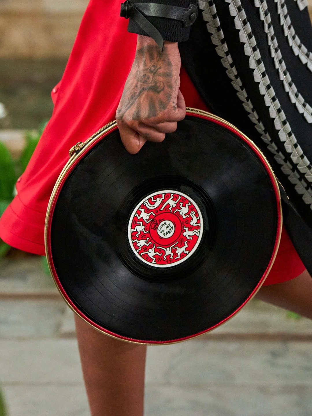 Black Louis Vuitton bag shaped like a vinyl record with Keith Haring artwork at its centre