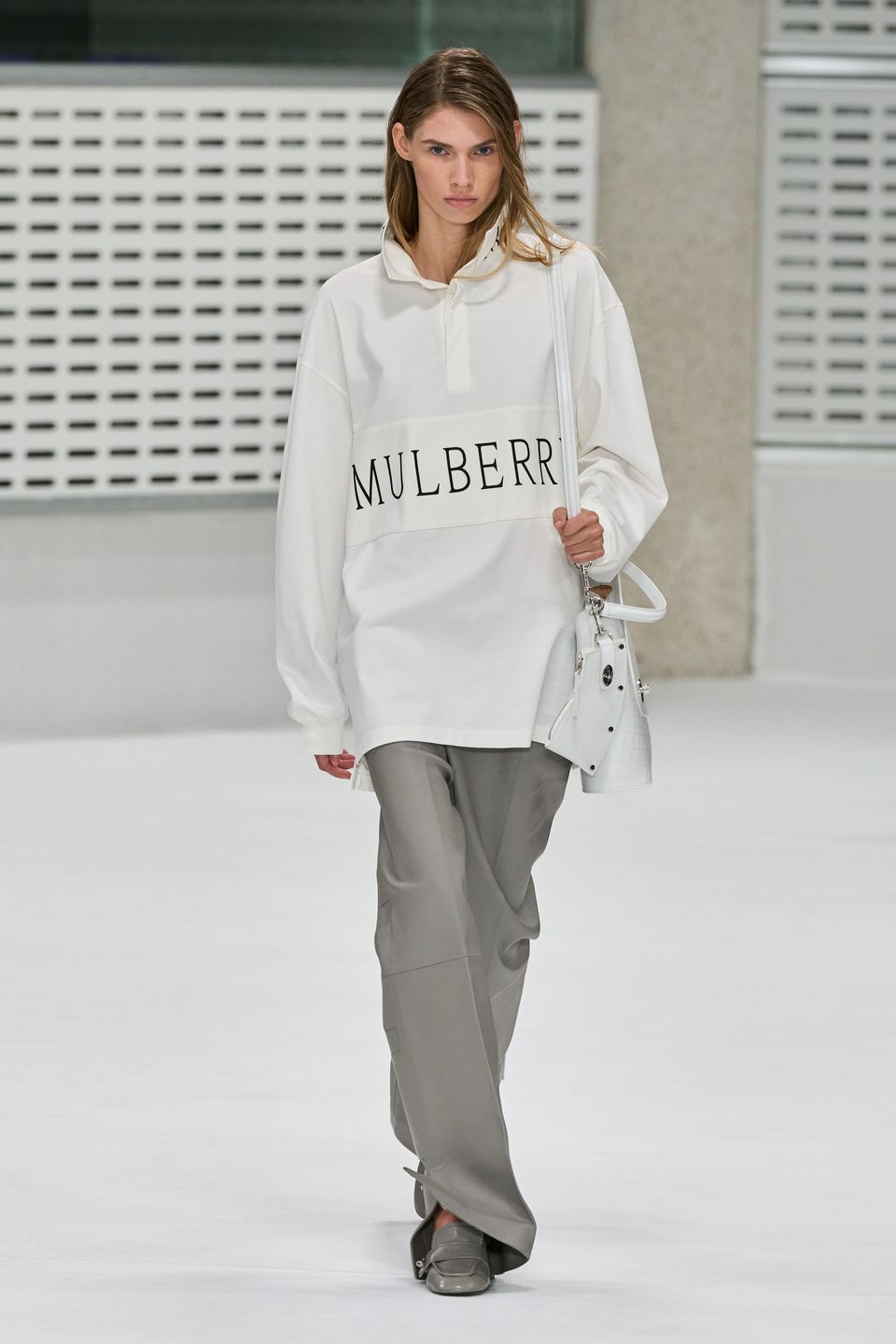 White Mulberry rugby shirt with grey trousers and a white bag on the Spring 2027 runway