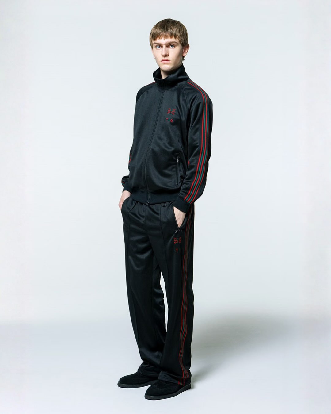 Model wearing the Needles x A Tribe Called Quest black track jacket and track pants