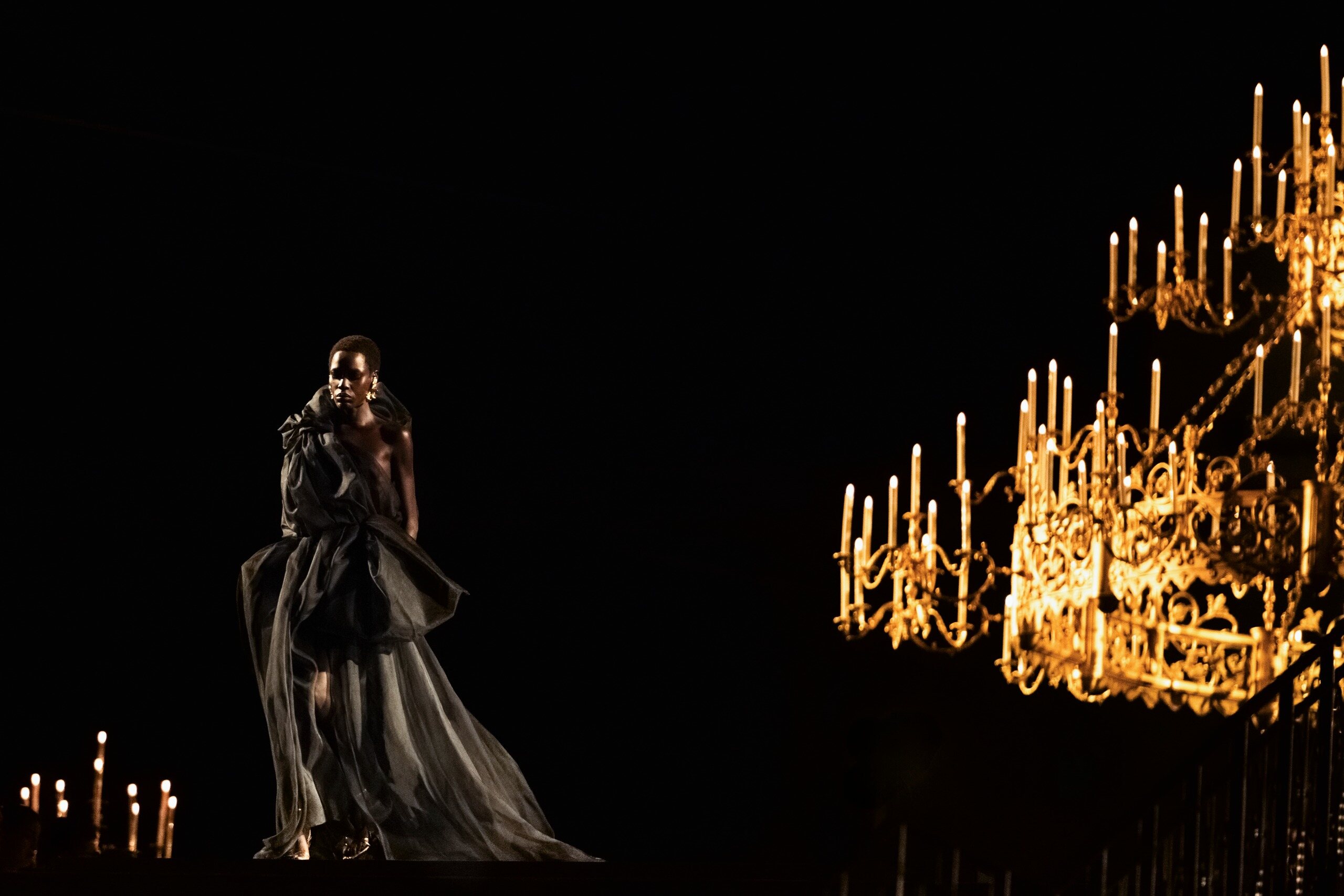 Gold Saint Laurent saharienne framed by giant chandeliers