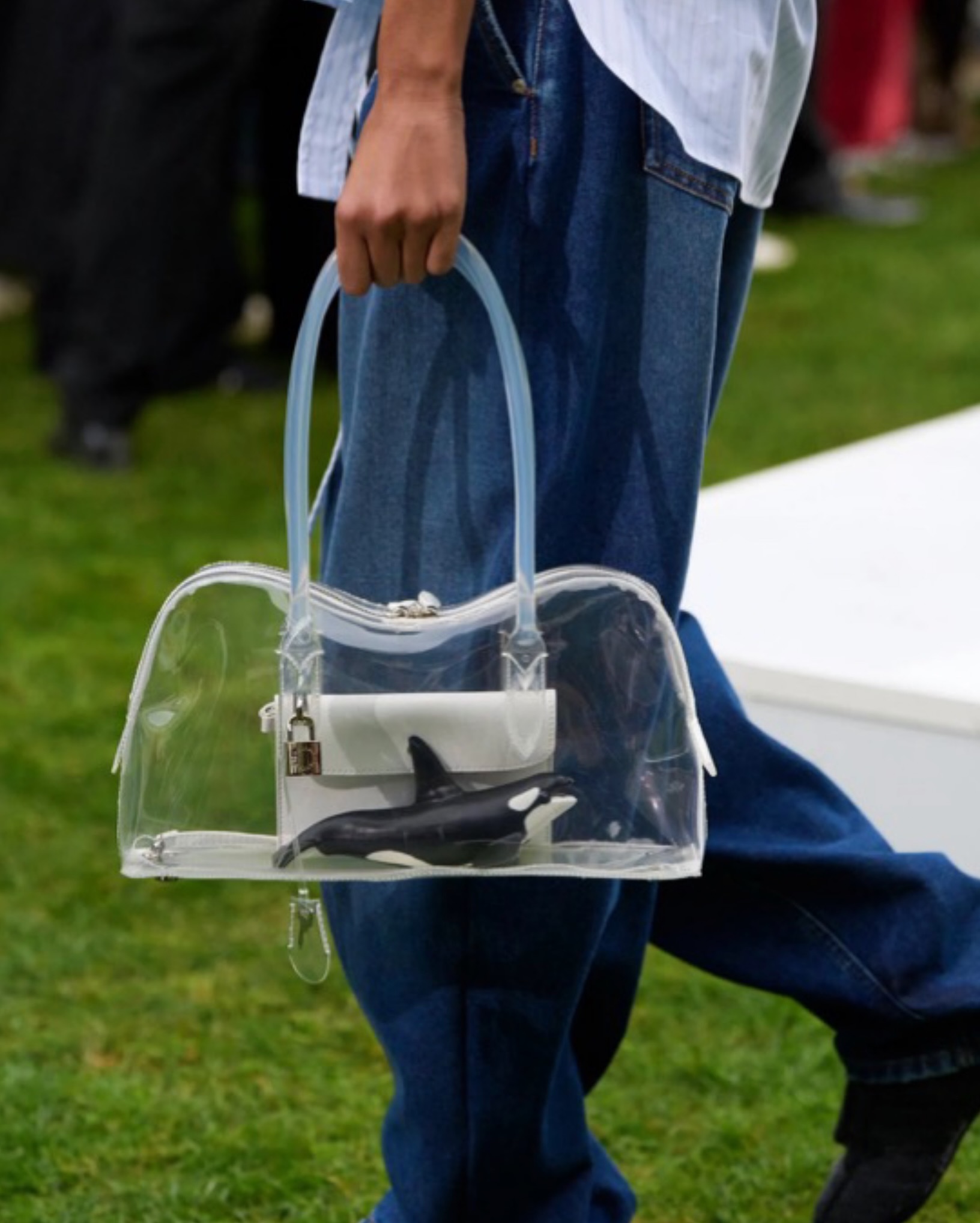 Transparent Stella McCartney holdall carrying a miniature orca and a small white bag