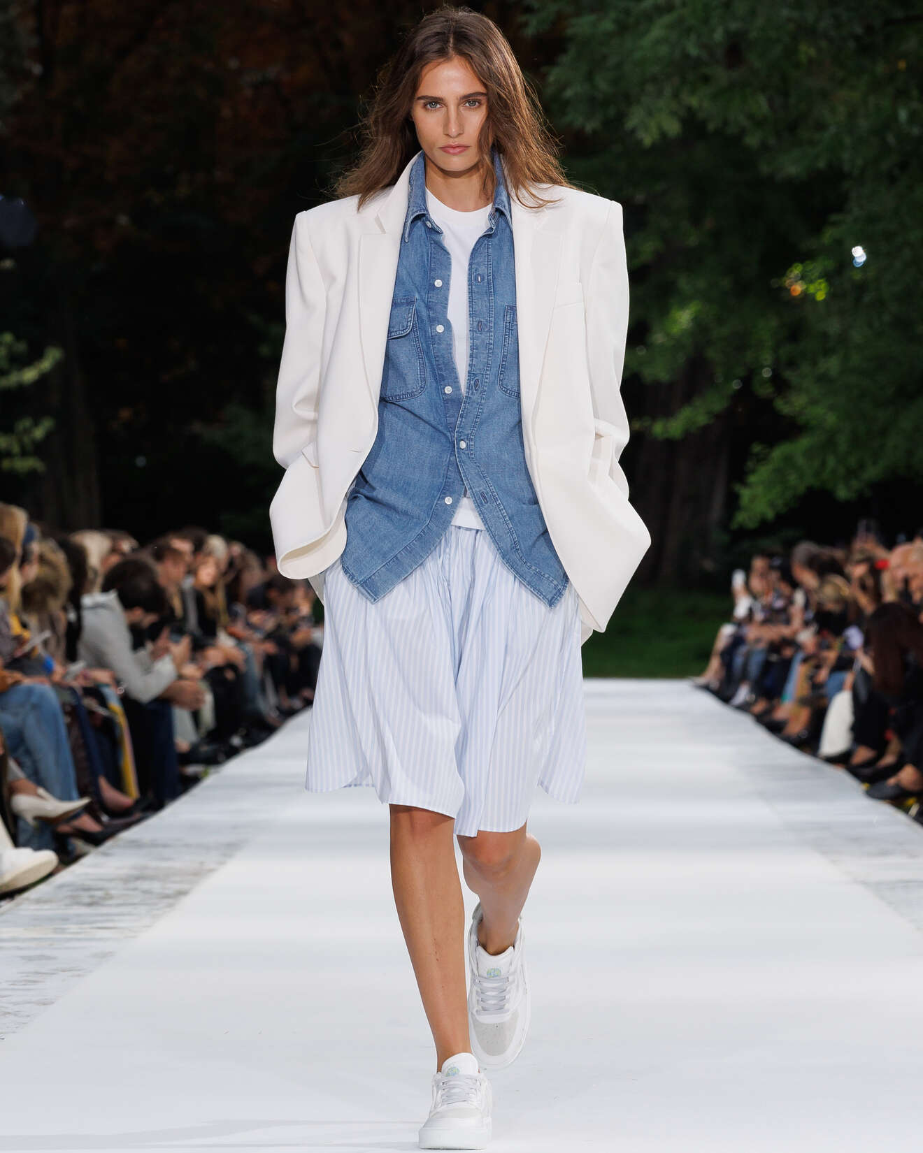 White oversized blazer layered over a denim shirt and striped shorts on the Stella McCartney Summer 2027 runway