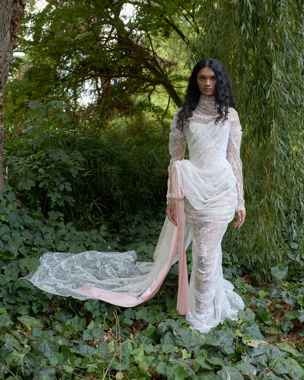 Sheer embroidered Vivienne Westwood bridal gown with a blush-pink ribbon and train